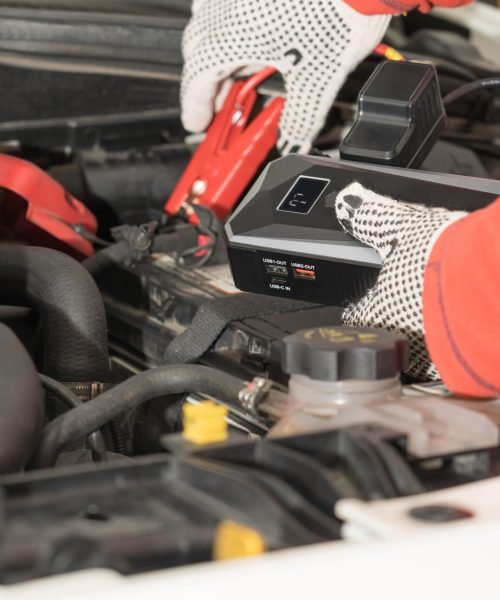 A closeup shot of a mechanic working on vehicle engines in a mechanical garage.